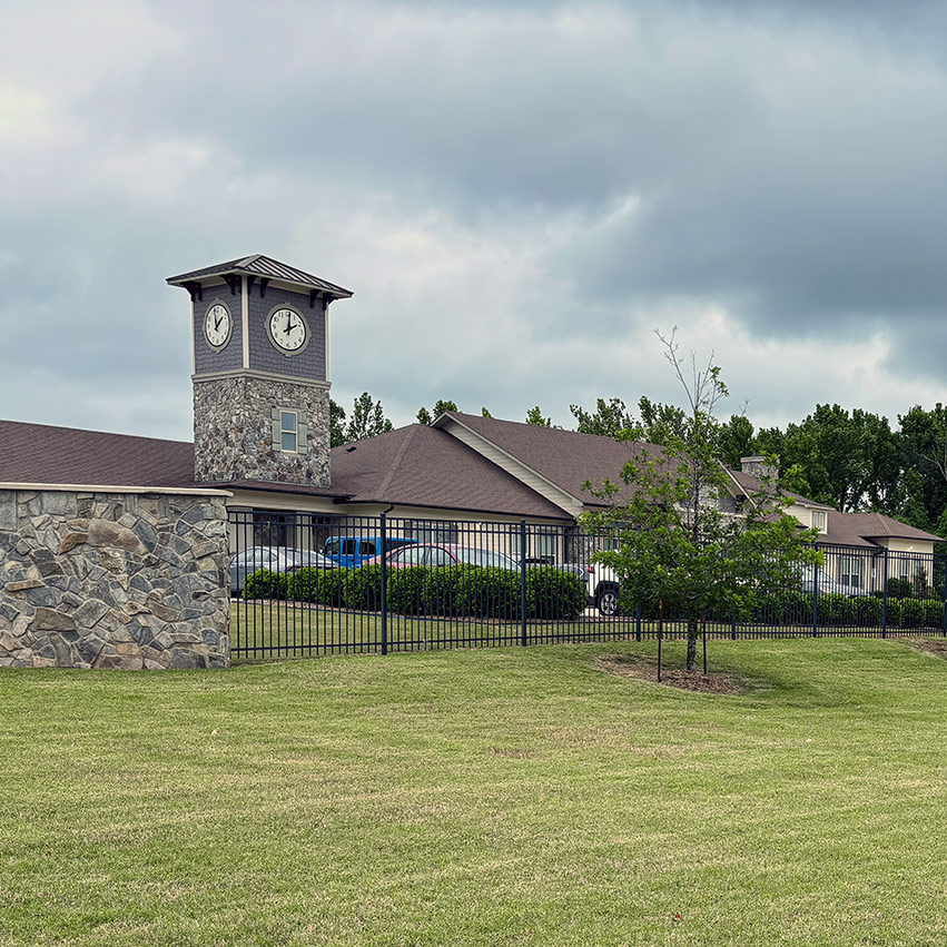 The exterior of Ridgemere, featuring a tall clock tower, surrounded by landscaped grounds.